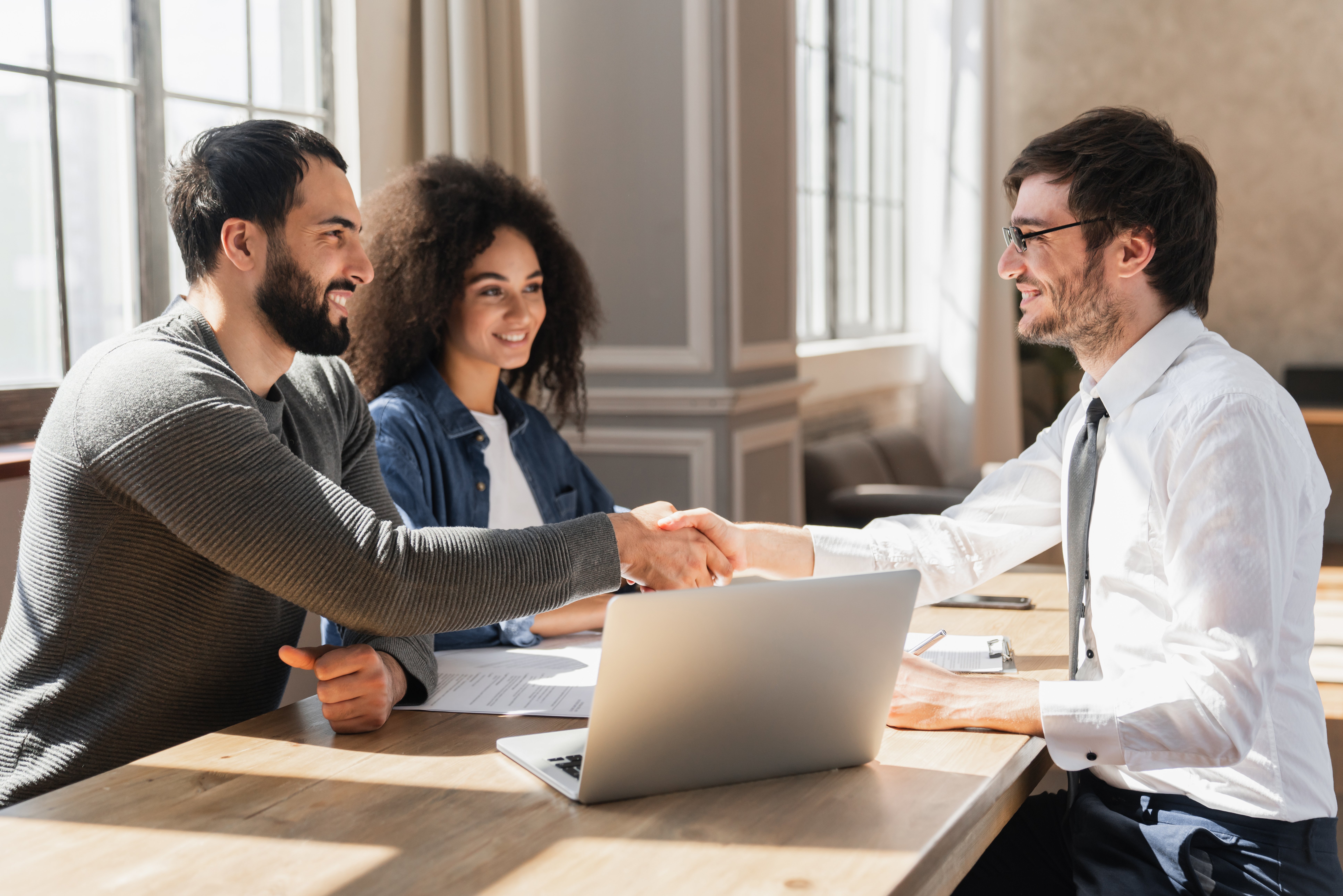 insurance broker shaking hands with couple